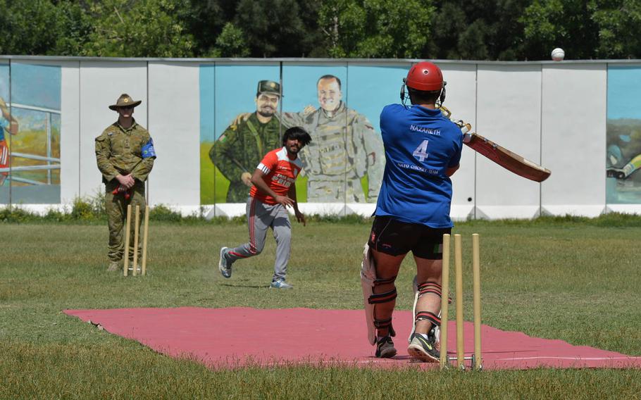 David Nazareth, an Australian on the Resolute Support cricket team, swings at a high-bouncing ball during an exhibition match between a team of NATO members and an Afghan squad from outside Kabul at the Resolute Support base in Afghanistan's capital on May 8, 2016.
