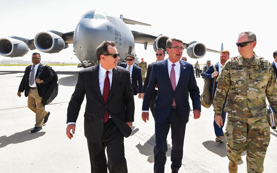 Defense Secretary Ash Carter is greeted by Army Lt. Gen. Sean MacFarland, commander of Operation Inherent Resolve, and U.S. Ambassador to Iraq Stuart Jones, as he arrives at Baghdad International Airport Monday, July 11, 2016.