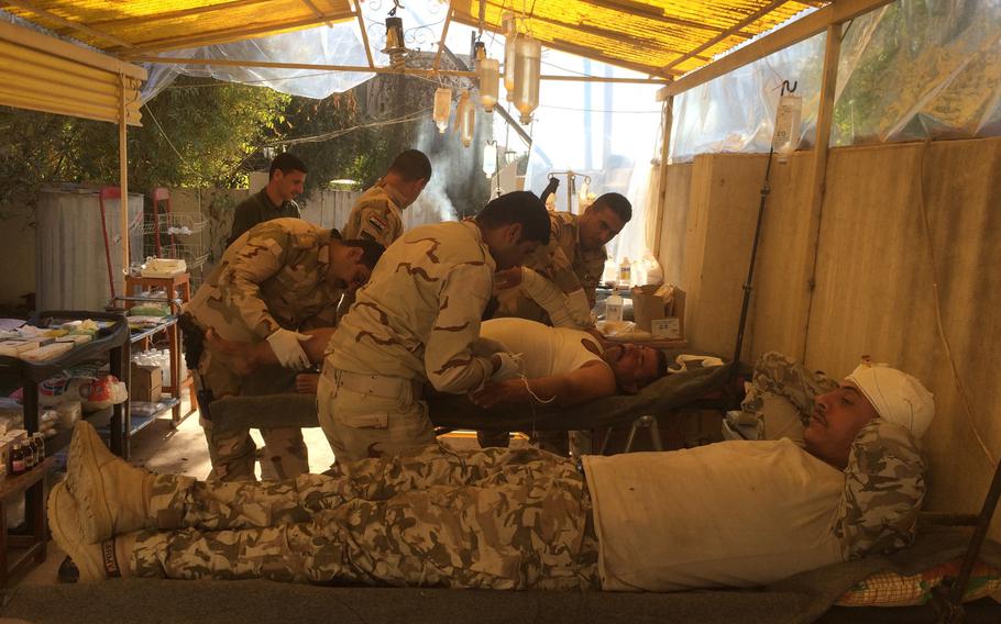 Iraqi soldiers injured during fighting in Mosul's al-Entsar district are treated at a field hospital in an abandoned house near the city on Thursday, Nov. 3, 2016.