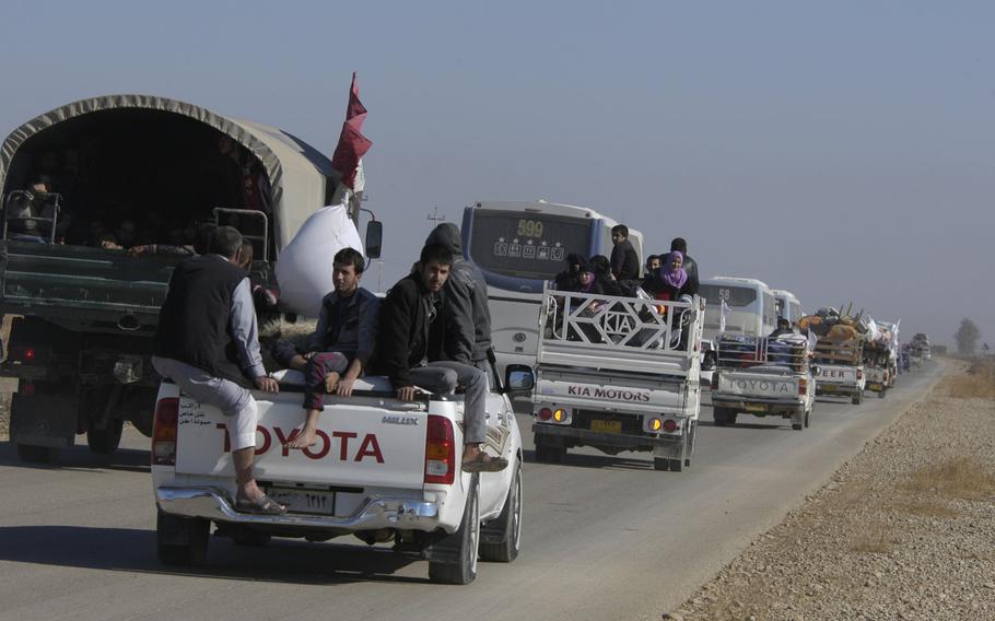 People fleeing fighting near the city of Mosul, where Iraqi forces are fighting to push out Islamic State militants, crowd onto trucks and buses along a major road out of the city on Thursday, Nov. 3, 2016.