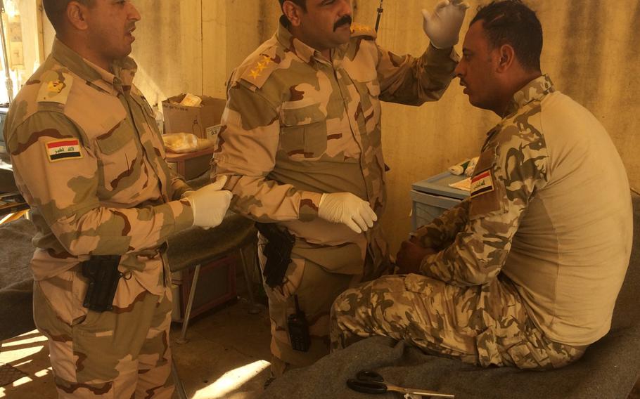 An Iraqi soldier injured while fighting the Islamic State in Mosul's al-Entsar district is treated at a field hospital in an abandoned house near the city on Thursday, Nov. 3, 2016.