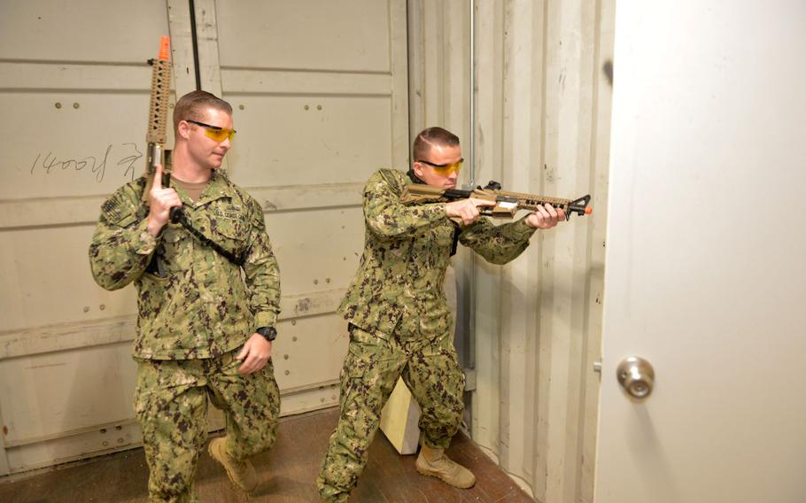 Coast Guardsmen Petty Officer 2nd Class Philip Cook, left, and Petty Officer 3rd Class Jake Brasker, from Patrol Forces Southwest Asia's Maritime Engagement Team, demonstrate boarding procedures in a facility is known as the ship-in-a-box on March 12, 2019 in Bahrain.