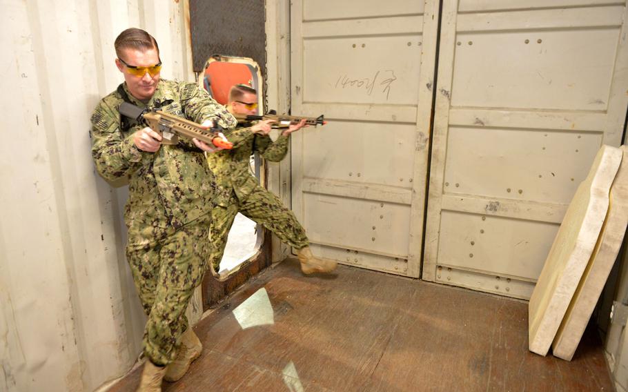 Coast Guardsmen Petty Officer 2nd Class Philip Cook, left, and Petty Officer 3rd Class Jake Brasker, from Patrol Forces Southwest Asia's Maritime Engagement Team, demonstrate boarding procedures in a facility is known as the ship-in-a-box on March 12, 2019 in Bahrain.