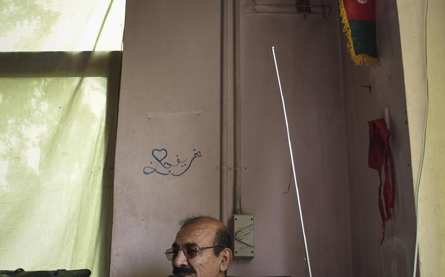 Capt. Ahmad Dullah of the Afghan police keeps a radio on his desk to keep him up to date on news of negotiations between the Taliban and American diplomats.