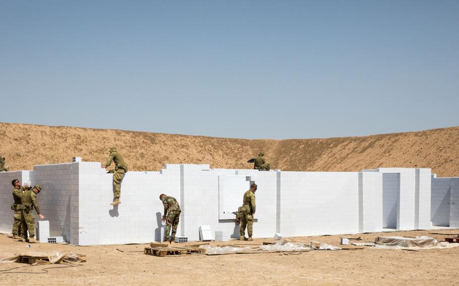 Australian and New Zealand soldiers with Task Group Taji, with the assistance of Iraqi instructors from the School of Infantry NCO II, install a new modular urban training facility on Camp Taji, Iraq, June 2, 2019.