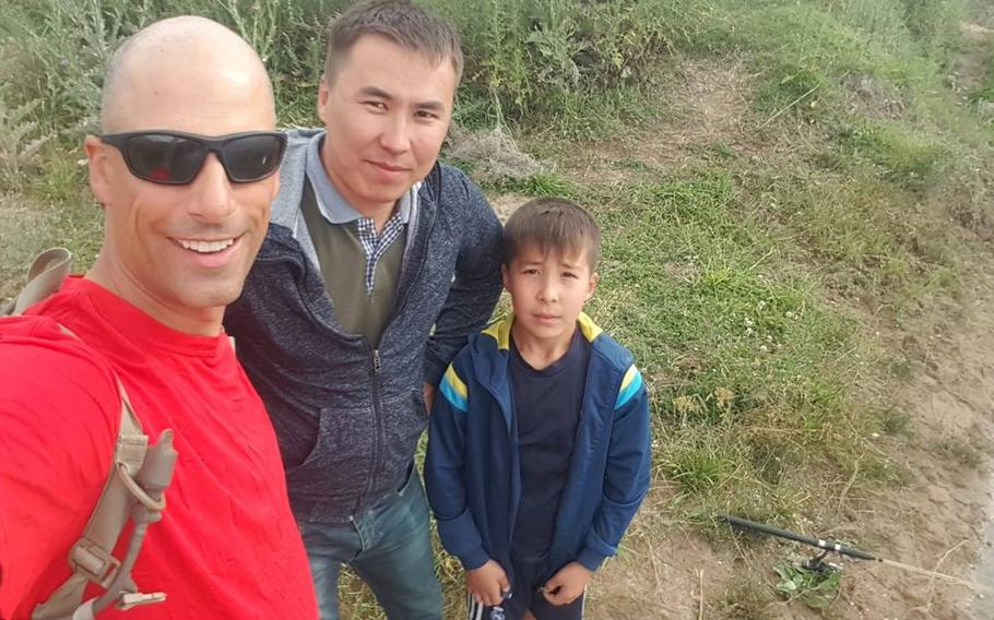 U.S. Army Sgt. 1st Class Kent Hecker, left, poses for a selfie with a father and son he met and fished with while hiking to a village near Illisky training area in Kazakhstan on his day off from the annual Steppe Eagle training exercise in June 2019.