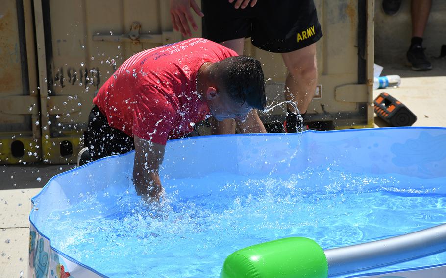 A U.S. soldier dunks his head in a miniature pool during Independence Day celebrations at Forward Operating Base Dahlke in Afghanistan's Logar province on Thursday, July 4, 2019. Temperatures at the base were around 90 degrees Fahrenheit around noon. 