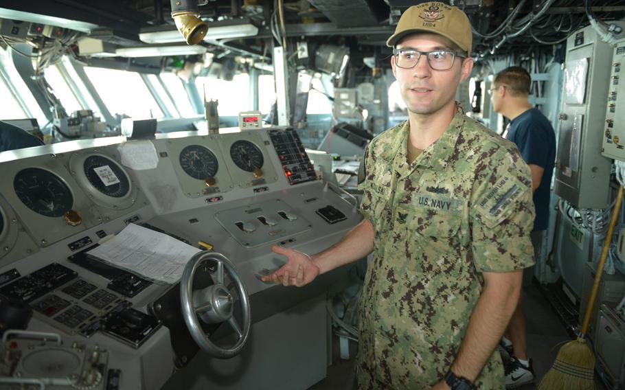 Petty Officer 2nd Class Jeremy Kowalski explains bridge operations on board the amphibious assault ship USS boxer on Aug. 1, 2019. 