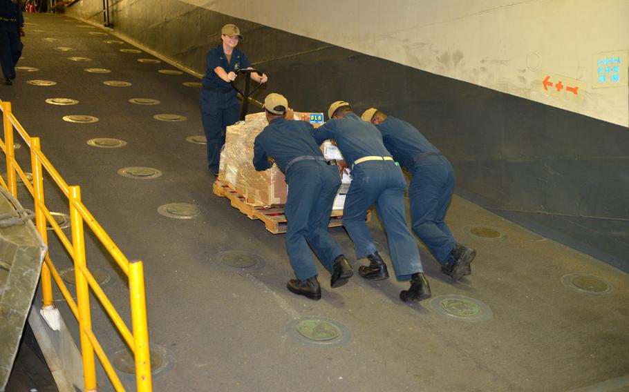 Sailors move cargo in the hangar deck on board the amphibious assault ship USS Boxer on Aug. 1, 2019. Boxer pulled into Bahrain on July 25 for a scheduled weeklong port visit just days after crew members downed at least one drone during inbound transit through the Strait of Hormuz.