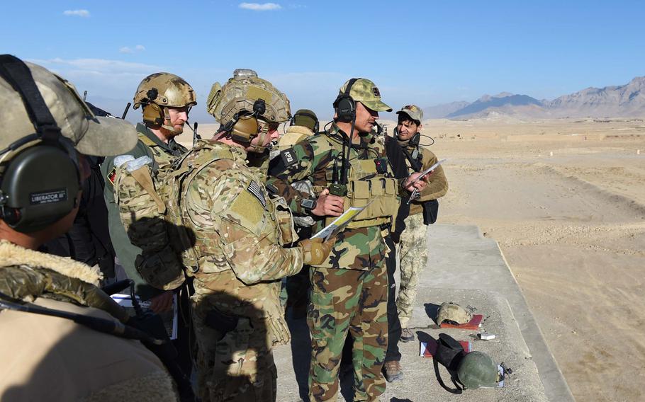 Under the supervision of two U.S. Army trainers, a student in a training program for Afghan Tactical Air Coordinators practices calling in an airstrike in 2016. According to a new Defense Department report, U.S. and coalition forces have failed to adequately develop the Afghans' airdrop capabilities.