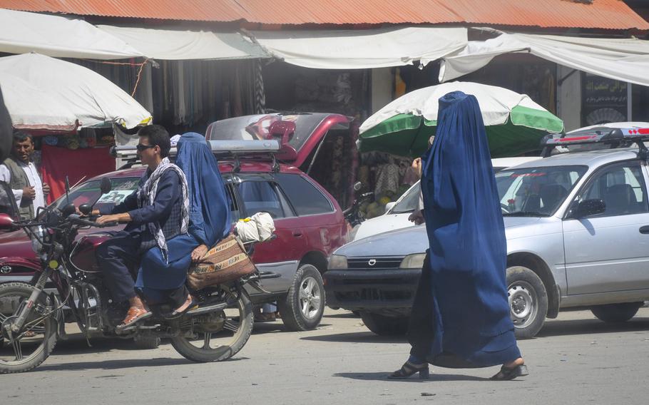 A local woman wears high heels under a chadaree, or Afghan burqa, as she walks through the markets of Faizabad, the provincial capital of remote Badakhshan province, July 15, 2019. Despite a Taliban statement early this year that said the group is "committed to all rights of women," locals in Badakhshan have said that, in the parts of the province controlled by the group, girls aren't allowed to go to school after sixth grade.