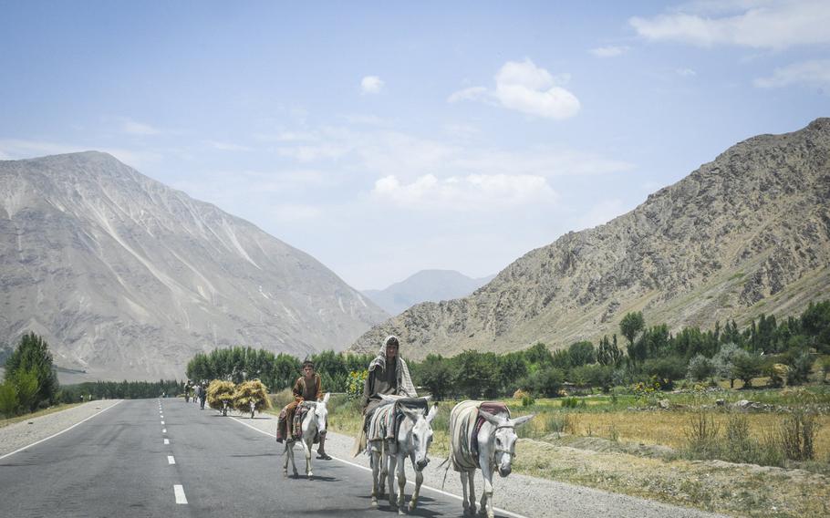 Farmers ride donkeys along a paved road in Afghanistan's Badakhshan province on July 14, 2019, bringing goods into Baharak, a district center under Taliban threat.