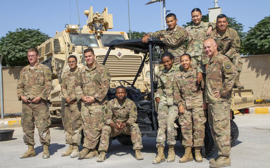 U.S. Army mechanics with Delta Company, 250th Brigade Support Battalion, pose around the Kawasaki MULE they restored in September at Joint Training Center-Jordan.