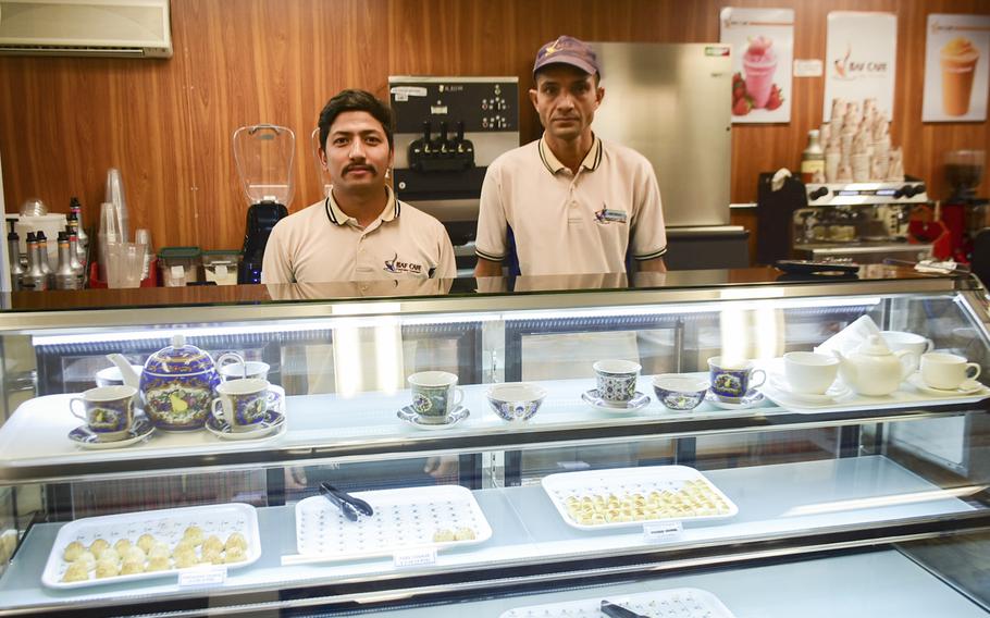 Sushil Budhathoki and Dev Raj Neupane, both workers from Nepal, show goods available at BAF Cafe at Bagram Air Base Sept. 19, 2019. The base?s newest eatery aims to offer troops an authentic Afghan tea shop experience.