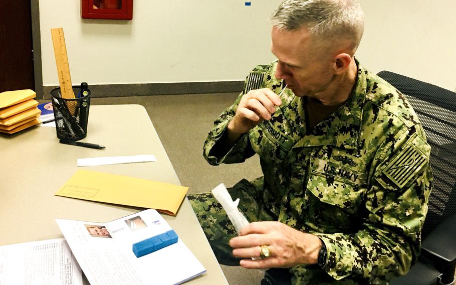 Navy Capt. Charles McDermott provides a cheek swab during a bone marrow drive at Naval Amphibious Task Force 51/5 headquarters in Bahrain on Oct. 24, 2019.
