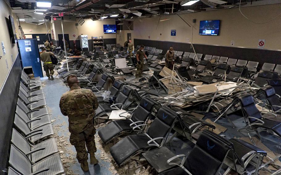 U.S. Air Force airmen from the 405th Expeditionary Support Squadron work together to clear debris inside the passenger terminal the day after a Taliban attack at Bagram Airfield, Afghanistan, Dec. 12, 2019.