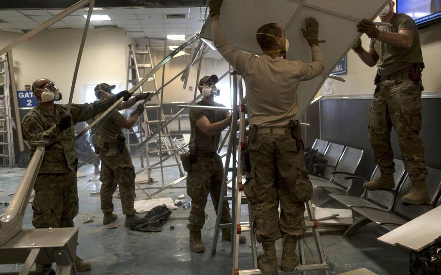 U.S. Air Force airmen from the 405th Expeditionary Support Squadron remove damaged metal and ceiling tiles inside the passenger terminal the day after a Taliban attack on Bagram Airfield, Afghanistan, Dec. 12, 2019.