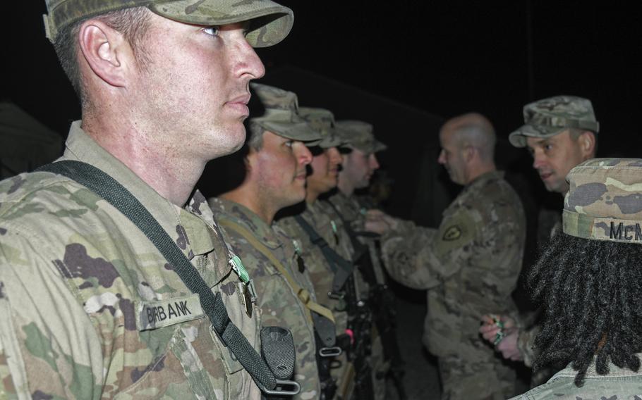 Staff Sgt. Bobby Burbank, left, and soldiers from 1st Battalion, 24th Infantry are presented with medals by Col. Matthew W. Brown, commander of the 1st Stryker Brigade Combat Team, 25th Infantry Division, Thursday, Dec. 26, 2019, at a small camp in Mosul, Iraq.