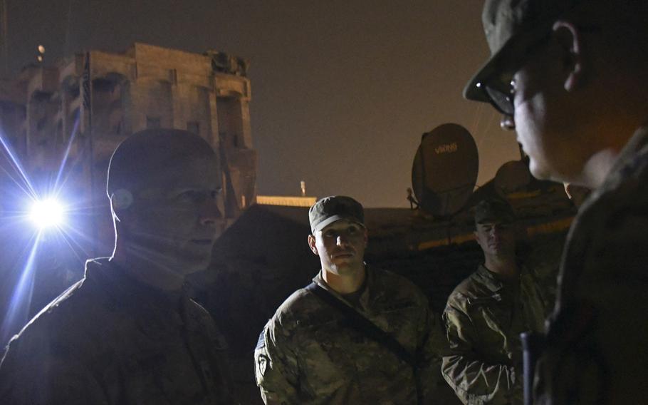 Col. Matthew W. Brown, left, speaks with Spc. Brandon Laycock from 1st Battalion, 24th Infantry after presenting him with a coin, Dec. 26, 2019, for his work on the communications networks at the camp in Mosul, Iraq, where the soldier is deployed.