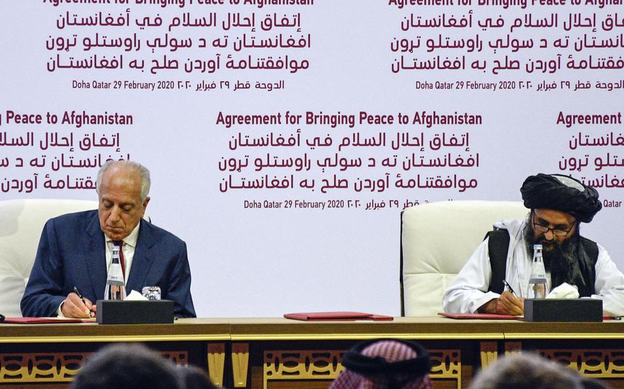 Zalmay Khalilzad, American special envoy for Afghan reconciliation, signs a peace deal with the Taliban, along with Mullah Abdul Ghani Baradar, the militant group's top political leader, in Doha, Qatar, Feb. 29, 2020. A threat to the accord may be the uncertainty over what each side agreed to, experts and lawmakers said.