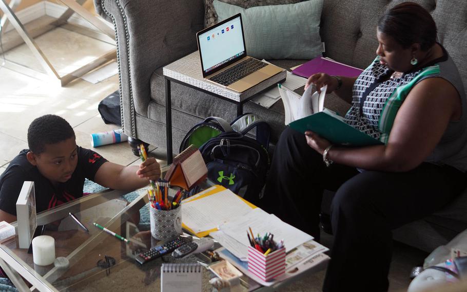 Xavier Turner receives help on his homework from his mother, Katherine, in their home in San Antonio, May 7, 2017. Xavier's father, Army Sgt. Maj. Wardell Turner, died in Afghanistan in 2014.