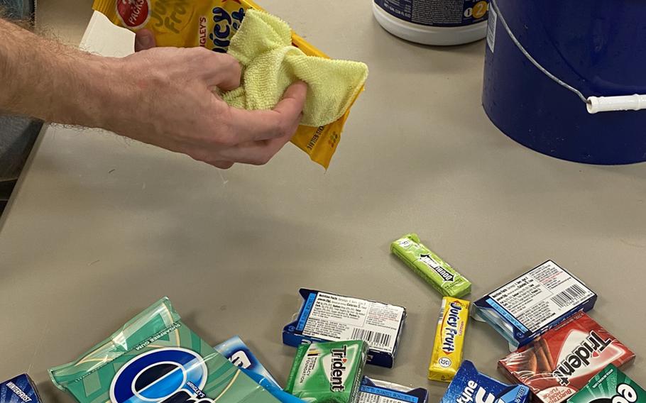 A worker with Support Our Troops, a charity based out of Tampa, Fla., sanitizes the surfaces of snacks such as gum and cookies before placing them in care packages for deployed service members April 8, 2020.