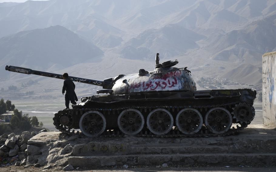 A boy plays on an abandoned Soviet tank on a side of a highway east from Kabul, Afghanistan, on Feb. 22, 2020, the first day of a declared period of reduced violence in the country.