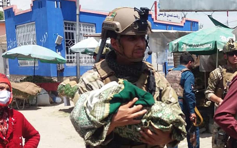 Afghan special operations police rescue women and children from a hospital under attack by militants in western Kabul, Afghanistan, on Tuesday, May 12, 2020. The attack targeted a maternity ward run by international humanitarian organization Doctors Without Borders, sources said.