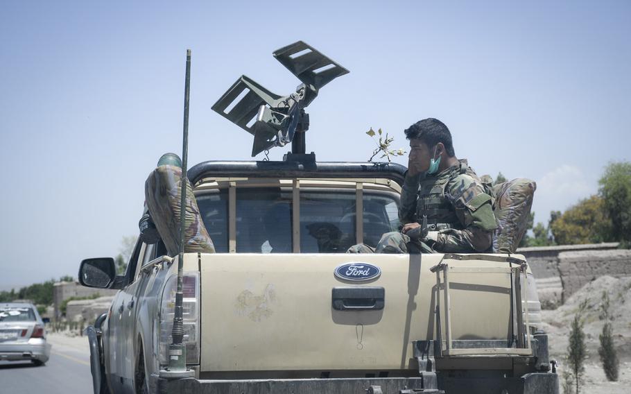 An Afghan soldier scratches his face after putting down his face mask in on a roadway in eastern Afghanistan May 10, 2020. Afghan health officials are concerned about mounting numbers of coronavirus infections as fighting continues between national forces and the Taliban.