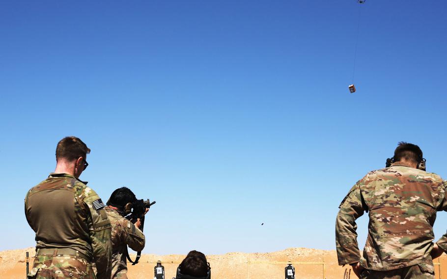 Soldiers take turns using a Smart Shooter sighting device to fire at a box carried by a drone during familiarization range training near al-Tanf garrison, Syria, May 30, 2020.