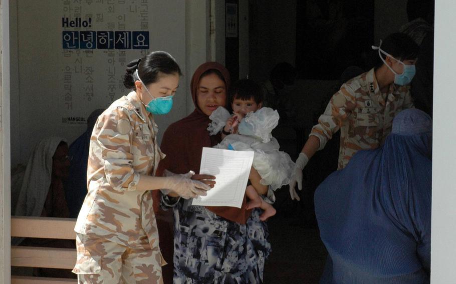 A South Korean army nurse escorts an Afghan woman through a medical wellness check at the Korean Hospital near Bagram Airfield, Afghanistan, in a photo taken April 25, 2007. The hospital was heavily damaged in a Taliban attack on Dec. 11, 2019, and now is being razed, NATO Resolute Support officials said this week.