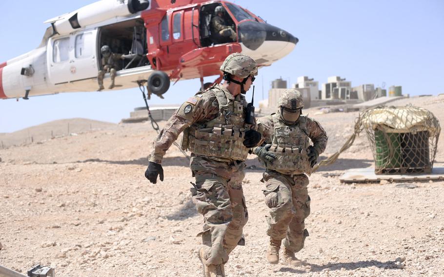 Spc. Richard Guevarra, left, and Spc. Christopher Crisostomo, of the Guam Army National Guard, return from hooking a slingload to a Task Force Sinai Aviation Company UH-60 Blackhawk, at a Multinational Force and Observers remote site in Saudi Arabia in September 2019. The Army has authorized soldiers who have served in Saudi Arabia  since September 2019 to wear combat patches.
