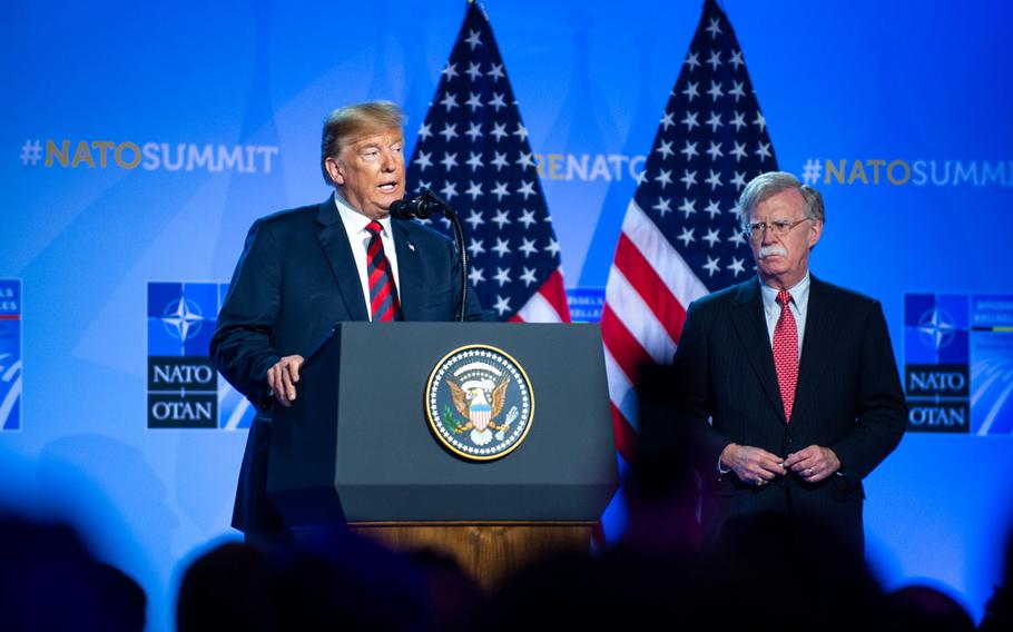 President Donald Trump and National Security Adviser John Bolton give a press conference at the NATO summit in Brussels in July 2018. Bolton recounted Trump's decisions on the war in Afghanistan in a book released Tuesday.