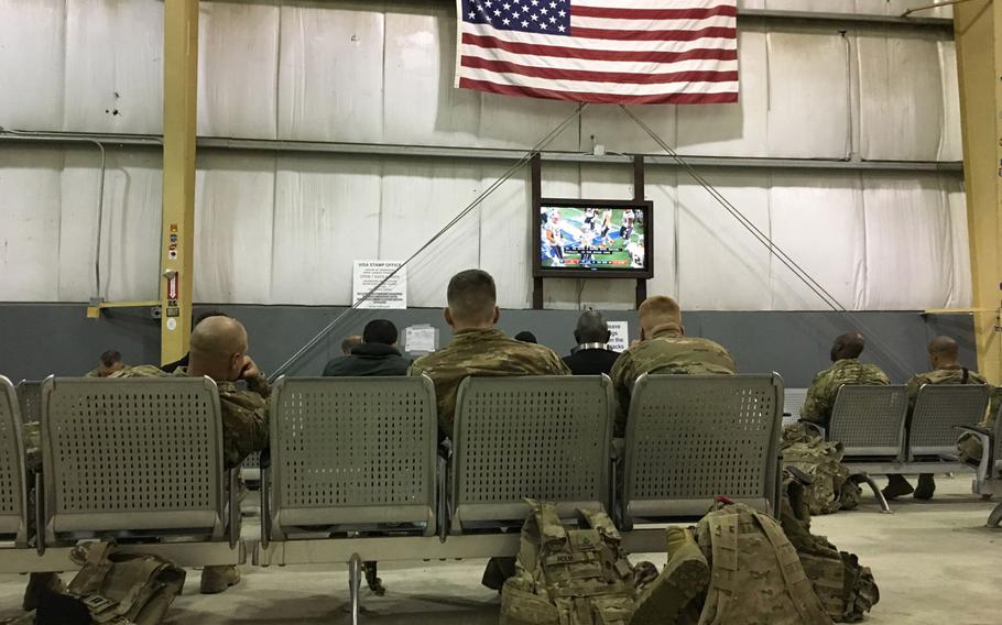 U.S. troops waiting for transport watch the Super Bowl at Bagram Air Field's rotary PAX terminal on Monday, Feb. 4, 2019. A bipartisan group of U.S. lawmakers has introduced a bill that would require Congress to oversee further drawdowns of American troops from Afghanistan.