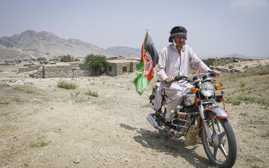 Hekmatullah, 20, a militia fighter in Achin district in eastern Afghanistan drives to his post on July 26, 2020. Hekmatullah stands guard at the same outpost where his father died fighting the Islamic State.