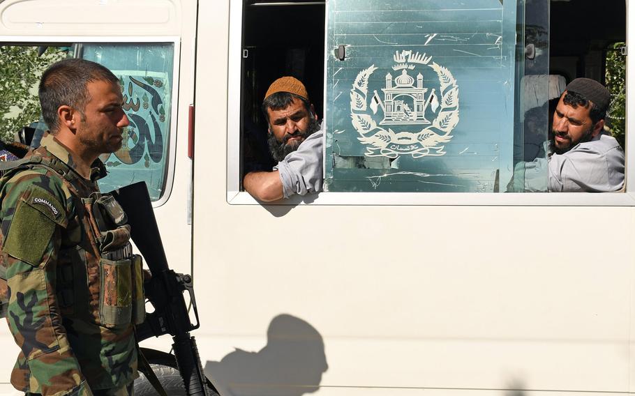 An Afghan soldier exchanges a glance with a Taliban prisoner being released from government custody in May. While violence has spiked across the country in recent months, on Friday the Taliban and government forces announced a three-day cease-fire to mark the Islamic holiday of Eid al-Adha.