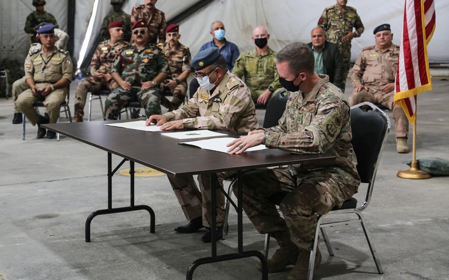 Iraqi Brig. Gen. Salah Muhammed Abdullah, and U.S. Air Force Maj. Gen. Kenneth P. Ekman, the deputy commander for operations for Combined Joint Task Force-Operation Inherent Resolve, participate in a signing ceremony to officially transfer Camp Taji to the Iraqi security forces at Camp Taji, Iraq, Aug. 23, 2020.