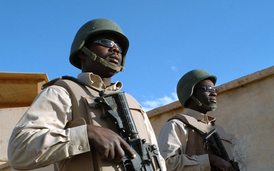 Two Ugandan contractors guard an American base in the Middle East in 2006. Of some 300 Ugandan guards at Operating Base Fenty near Jalalabad, in eastern Afghanistan, a majority tested positive for the coronavirus in June.