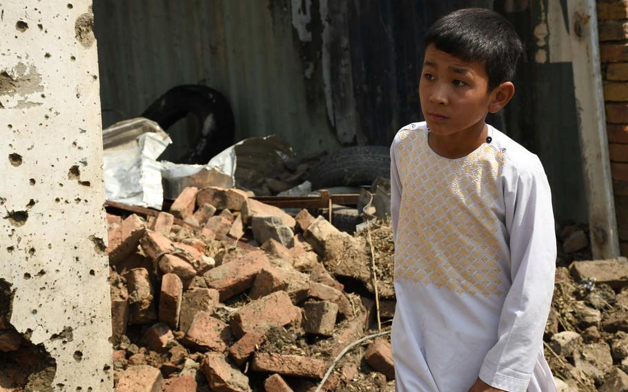 An Afghan boy inspects damage caused by a bomb blast in Kabul on Wednesday, Sept. 9, 2020. First Vice President Amrullah Saleh, who was the target of the attack, was only slightly injured in the blast, which killed at least 10 civilians.