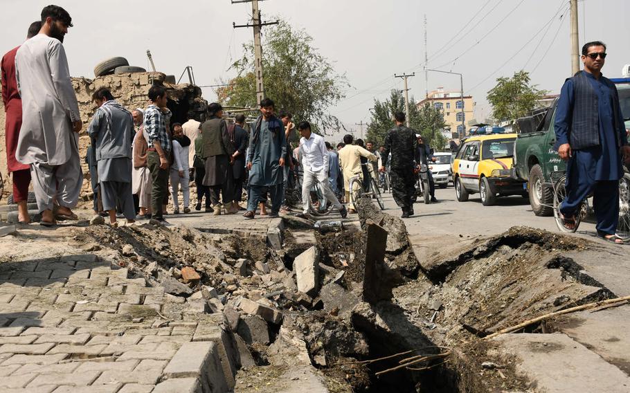 Kabul residents pass by the site where a bomb targeting First Vice President Amrullah Saleh left 10 civilians dead on Sept. 9, 2020, flattened  buildings and carved a crater into the road. Saleh was only slightly injured in the powerful blast, which he said melted the windows of the car he was in.