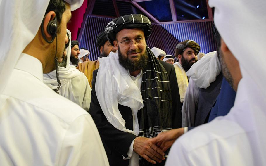 A Taliban official greets others Feb. 29, 2020, in Doha, Qatar, after the group signed a deal with the U.S. that would lead to the full withdrawal of foreign forces from Afghanistan if the Taliban meets the conditions spelled out in the agreement. The Taliban said they expect the United States and President-elect Joe Biden to continue following the deal.