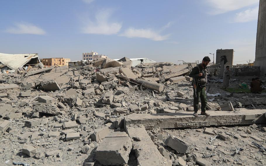 A middle eastern militant looks at debris in Yemen. 