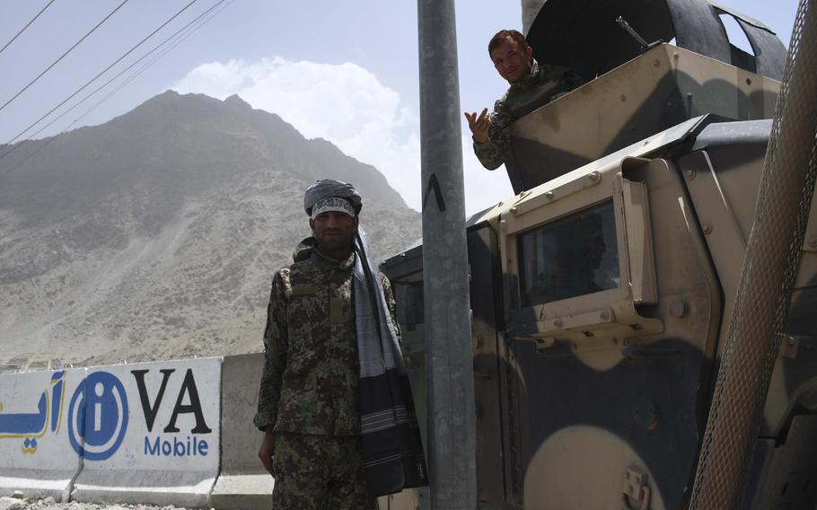 A soldier with the Afghan National Army wears a white headband often worn by the Taliban during the last day of unprecedented mutual cease-fires between the Taliban and the Afghan government over the weekend. Across the country, photos of Taliban and government troops taking photos of each other in peace spread online as fighting stopped in most provinces. 