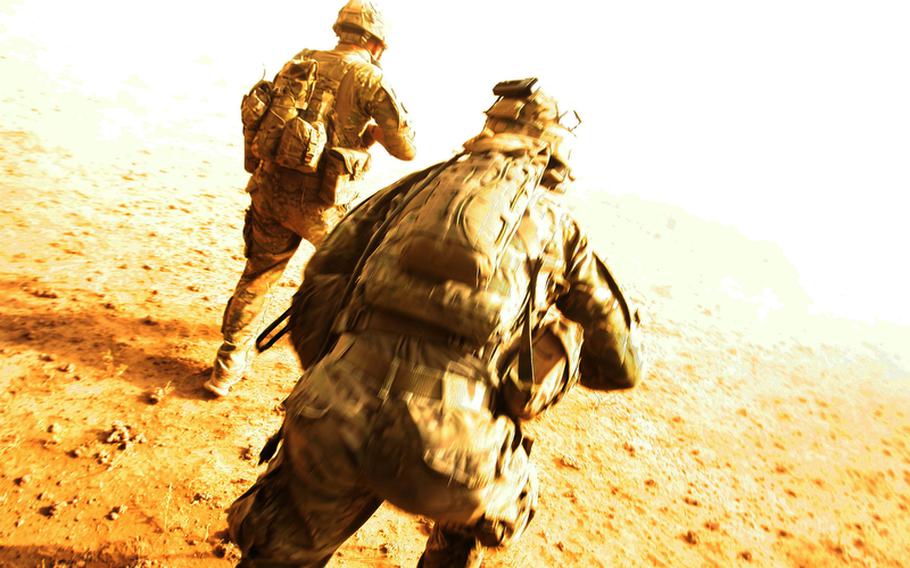 Spc. Lynn Schell, left, and Staff Sgt. Donald Thompson, both Pathfinders with 4th Battalion, 101st Aviation Regiment, 159th Combat Aviation Brigade, 101st Airborne Division, run from their Black Hawk helicopter after being dropped in the Registan Desert for a mission on Oct. 4, 2011, in Kandahar province, Afghanistan.