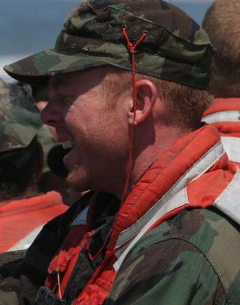 Sunburned Navy SEAL candidates stand at attention on the beach