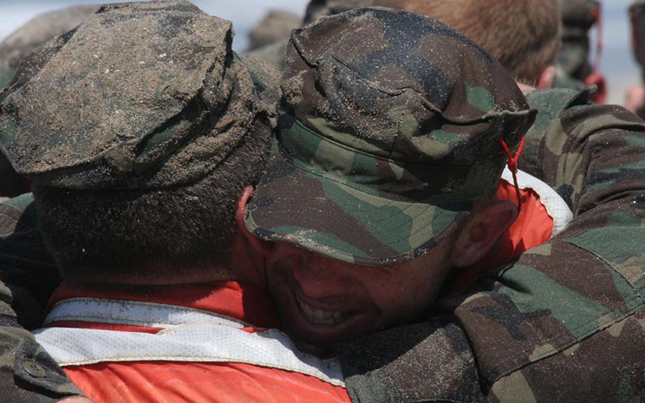 Navy SEAL candidates form a group hug Aug. 13, 2010, after a surprise visitor, Defense Secretary Robert Gates, informed them their seven-day "Hell Week" was completed.