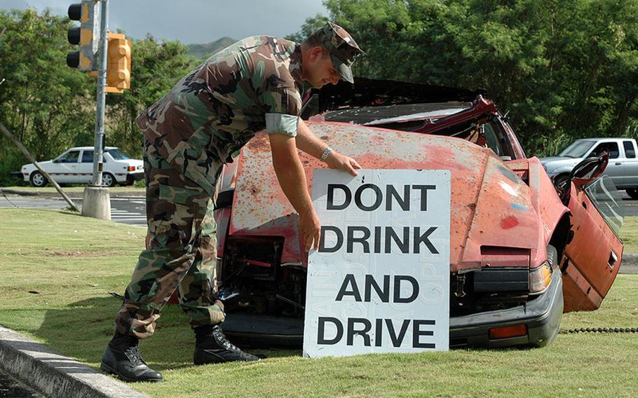 A sailor sets up an anti-DUI display at Naval Base Guam. The military actively campaigns against drunken driving, but a judge ruled that Marine Base Quantico went too far by double-prosecuting Marines for the offense.