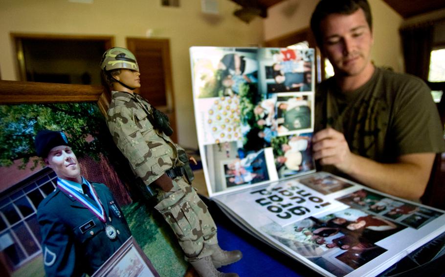 Troy Peterson looks over photos left on the dining room table, June 9, 2009, from a memorial service for Trevor Hogue, an Army soldier who had served in Iraq and returned home with post-traumatic stress disorder and committed suicide. Peterson and Hogue had been friends since they were in kindergarten. 