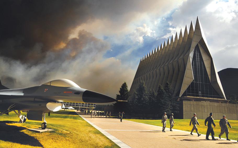 An ominous cloud of smoke from the Waldo Canyon fire rises from the south behind the Air Force Academy's Cadet Chapel as cadets head for a briefing on evacuation procedures June 27, 2012. 
