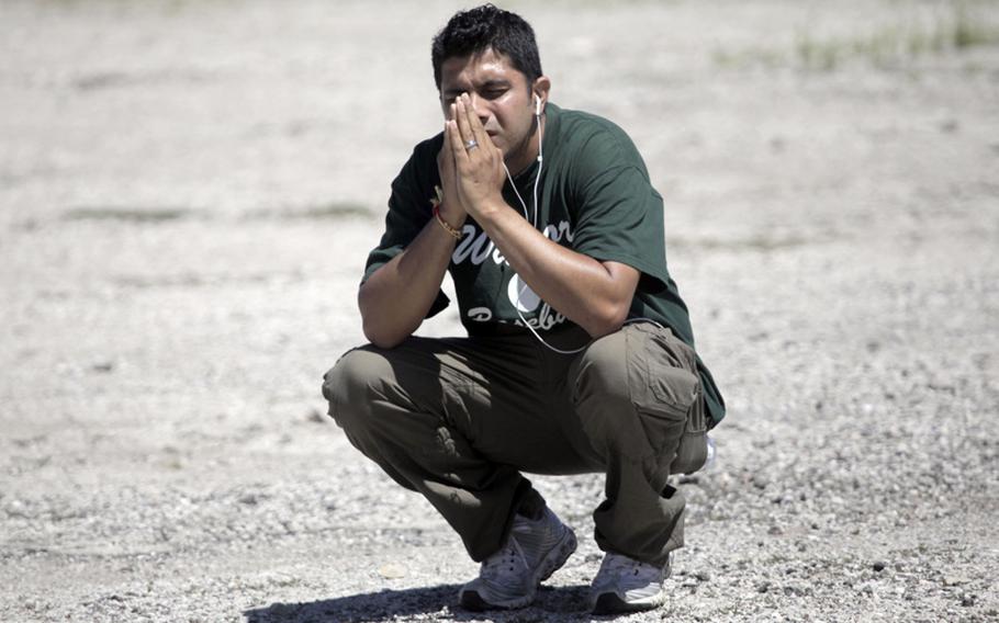 Amardeep Kaleka, whose father is Satwant Kaleka, the president of the temple who was shot, prays in a parking lot while waiting to hear information at the Sikh Temple, in Oak Creek, Wisconsin, on Aug. 5, 2012. 

